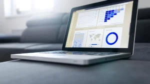حاسوب محمول يعرض جداول بيانات بجوار مستندات ورقية لتحويل PDF إلى Excel