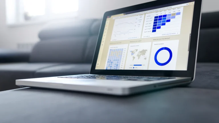 حاسوب محمول يعرض جداول بيانات بجوار مستندات ورقية لتحويل PDF إلى Excel